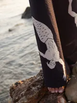 Pantalón palazzo negro con estampado de sirenos blancos y cintura elástica.