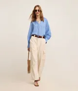 Pantalón wide leg color beige confeccionado en sarga sastrería, de cintura alta, sin estampa y con bolsillos cargo en los laterales.