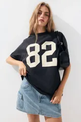 Remera oversized gris oscuro de punto suave de algodón con el número 82 estampado en blanco.
