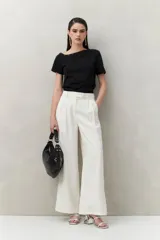 Top tejido azul marino de silueta ajustada con diseño minimalista y escote asimétrico, adornado con pequeños botones metálicos.