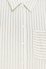 Camisa de manga larga con cuello solapa, a rayas verticales grises y blancas. Tiene un bolsillo de plastrón en el delantero y cierre frontal con botones.