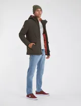 Parka verde militar de nylon con forro capitoneado color naranja, capucha con piel sintética desmontable, relleno de guata, bolsillos en pecho y bajos con cierre y parche personalizado en manga.