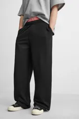 Pantalón jogger negro de corte ancho, confeccionado en tejido de algodón con interior de rizo. Cuenta con cintura elástica ajustable con cordón interior, bolsillos laterales y bolsillo trasero de parche.