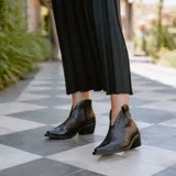 Botines de cuero vacuno color blanco con diseño bordado, taco de madera foliado en cuero de 5cm, cierre del lado interior y horma de punta fina.