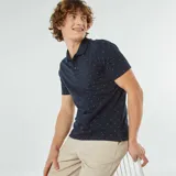 Remera polo azul marino de piqué de algodón con estampado de pequeños detalles geométricos en blanco y rojo.