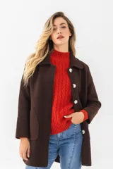 Saco negro de paño con cuello solapa y cierre con tres botones grandes.