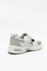 Zapatilla negra con tira ajustable y velcro.