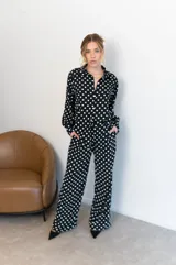 Camisa negra con estampado de lunares blancos, de manga larga y cuello clásico.