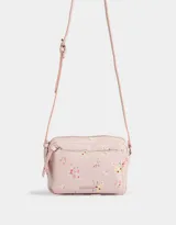 Bandolera pequeña de cuerina color rosa pálido con estampado floral multicolor. Tiene bolsillo frontal con cierre, correa regulable, cierre superior y tag metálico con logo.