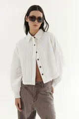 Camisa de color bordó con tablas en la parte frontal, puños elásticos y cuello clásico.