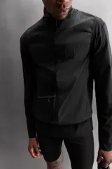 Chaleco negro de tejido técnico con estructura ripstop y ligero acolchado interior. Cuello alto ajustable con elástico, manga sisa, bolsillos de seguridad con cremallera en pecho y cadera, acabados con cinta elástica, cierre frontal con cremallera y logo estampado en el bajo.