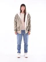 Campera color beige con interior de piel sintética blanca, capucha, cierre frontal con botones a presión, bolsillos laterales con solapa y puños elásticos.