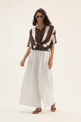 Pantalón palazzo de lino con estampado a rayas verticales en tonos blanco y gris.