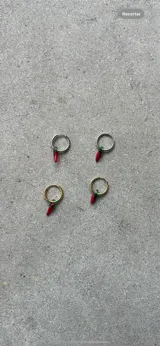 Aros colgantes con forma de argolla dorada y dije de ají rojo con detalles en verde.