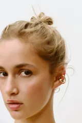 Pack de dos aros dorados: uno tipo earcuff con forma de espiral y otro con forma de C.