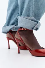 Sandalia de tacón fino color rojo, con tira delantera ancha, pulsera de tobillo con hebilla metálica y punta metálica.