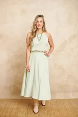 Pollera larga evasé color verde claro, con cintura alta y cinturón de la misma tela.