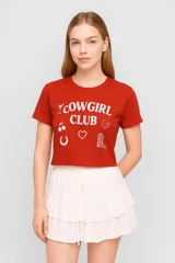 Remera corta color ladrillo con estampado frontal de texto 'Cowgirl Club' y dibujos de un trago, cerezas, herradura, corazón, bota y dados.