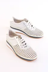 Zapatillas plateadas de cuero con diseño calado y cordones. Plataforma con detalles en negro, blanco y naranja.
