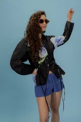 Camisa negra con estampado de flores y libelulas, con cuello clásico, mangas largas abullonadas y fruncido tipo corset.