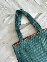 Bolso tote de cuero color marrón con diseño entrelazado.