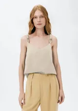 Musculosa color beige con escote en V y tirantes anchos ajustables con hebillas metálicas.