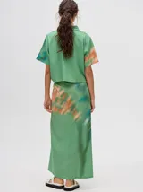 Falda midi marrón con estampado floral en tonos lila, abertura lateral y tiras ajustables.