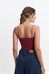 Top color borgoña con breteles finos, escote fruncido y abertura en el abdomen.
