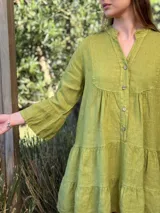 Vestido corto negro de lino, con escote en V, botones frontales y mangas largas acampanadas con volados.