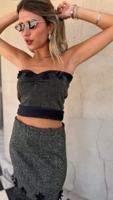 Top strapless tejido con hilo lurex negro y dorado, con escote corazón y detalles de apliques de crochet negros en el borde superior.