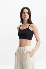 Top corto negro de breteles finos y tejido de punto acanalado.