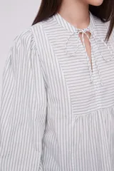 Blusa de manga larga con diseño a rayas en tonos claros y cuello con lazo.