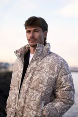 Campera puffer de corderoy con estampado paisley en tonos beige y cuello alto.