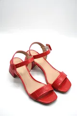 Sandalias plateadas con taco bloque bajo y tira delgada sobre los dedos.