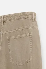Pantalón cargo de denim color beige, corte relaxed fit, con bolsillos laterales tipo parche con solapa y cierre frontal con botones.