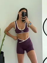 Conjunto deportivo color borgoña compuesto por un top con breteles anchos y un short de calce ajustado con cintura cruzada.