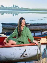 Vestido camisero largo color verde militar, confeccionado en lino, con cuello clásico, mangas largas con puños abotonados y cierre frontal con botones. Incluye un bolsillo de parche en el pecho.