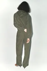 Cazadora bomber verde militar con capucha, cierre frontal con cremallera y bolsillos delanteros.