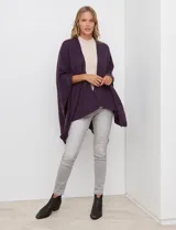 Ruana de tejido suave color morado oscuro, con cuello redondo y corte amplio tipo capa.