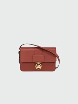 Bandolera Longchamp modelo Box Trot, color terracota, con correa ajustable y logo dorado en el cierre.