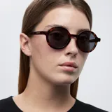 Gafas de sol redondas con montura carey y lentes negras polarizadas. Fabricadas con material bio-based G850 y patillas de propionato de celulosa. Protección UV400.