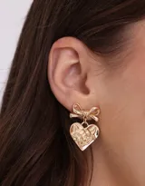 Aros colgantes dorados con forma de corazón y moño en la parte superior.