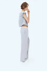 Pantalón de felpa celeste, de corte relajado con cintura elástica fruncida, bolsillos laterales discretos y piernas rectas.