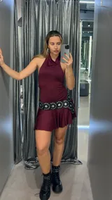 Minivestido marrón con cuello halter, falda con volados y cinturón con tachas.