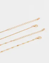 Collar doble dorado, uno corto con dije de rosa y perla, y otro largo con dije de rosa con tallo.