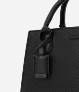 Cartera satchel negra de material sintético con textura diagonal, doble asa de mano y asa larga removible de gross. Incluye porta monedas y cierre por cremallera.