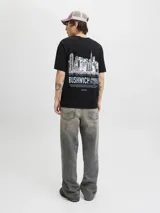 Remera negra de manga corta y cuello redondo, con fit relajado y estampado frontal con la palabra "BUSHWICH" y el texto "EMBRACE THE CITY". Confeccionada en punto single jersey orgánico.