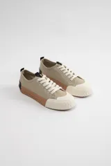 Zapatilla beige con suela de goma y detalles en color crema, diseño casual y confortable.