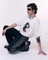 Pantalón unisex de denim 100% algodón con lavado Gradient Black. Tiro medio, calce wide/relajado, pierna amplia y caída larga. Cintura con elásticos laterales, costuras curvas y bolsillos delanteros y traseros curvos.