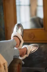 Pantuflas marrones con interior de corderito color crema.